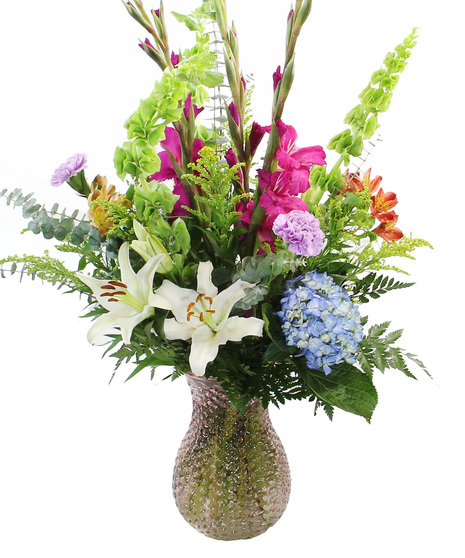 A floral work of art in our luxury collection, The Monet features hydrangea, Oriental lilies, Peruvian lilies, bells of Ireland, gladioli and more in a textured glass vase.