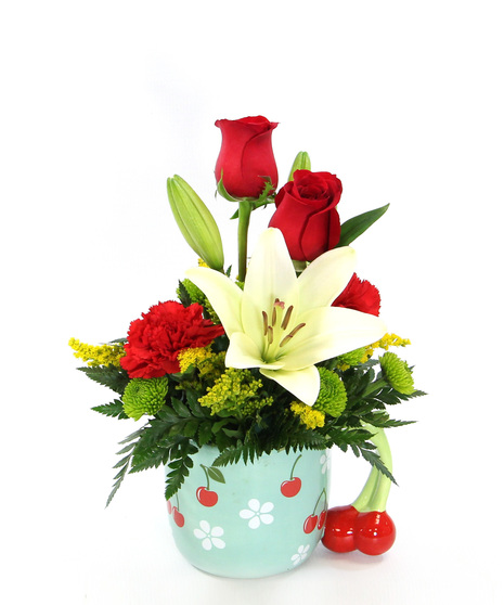 Two gifts in one! A bouquet featuring a white Asiatic lily complemented by vibrant red carnations and more in a ceramic cherry mug.  A perfect gift to brighten someone's day.