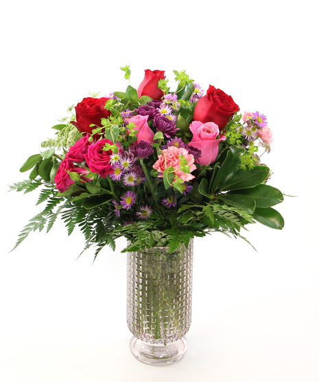 Perfect for your Valentine, Romance is designed in pinks and purples showcasing roses and charming accents in a pale pink pedestal vase.  