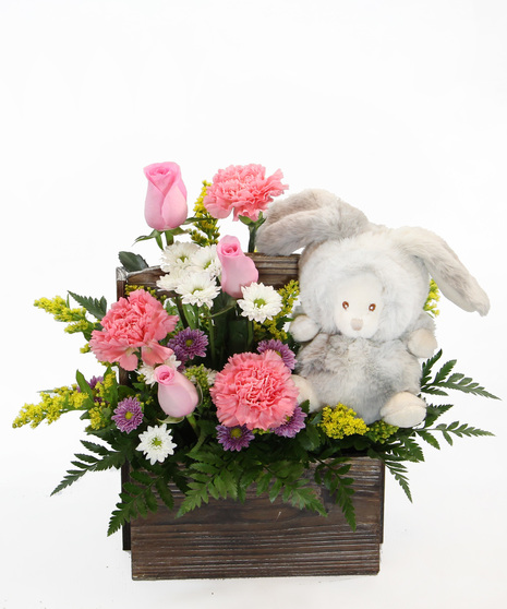 Our New Arrival bouquet is available in pink or blue tones, this design comes nestled in a wooden box, accompanied by a plush bunny. 