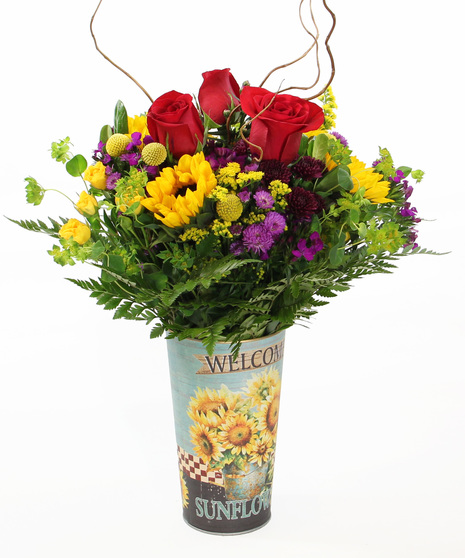 Radiant sunflowers, spray roses, and fall poms and accents in a sunflower tin. Its vibrant colors make it a wonderful gift to celebrate any occasion.