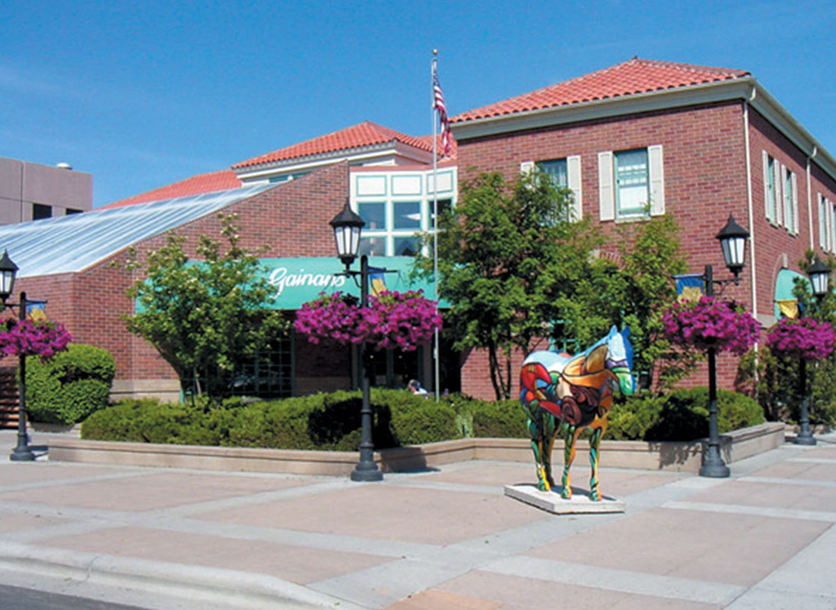 A colorful statue and gorgeous hanging flowers outside our downtown location